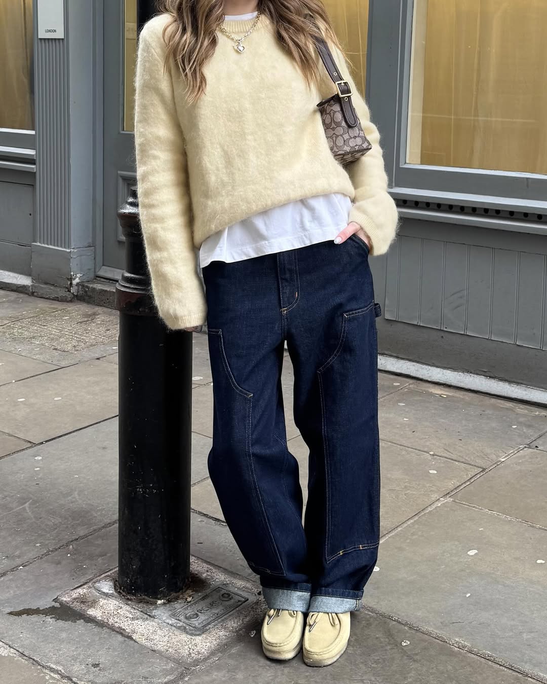 Look clássico com suéter amarelo claro e jeans escuro