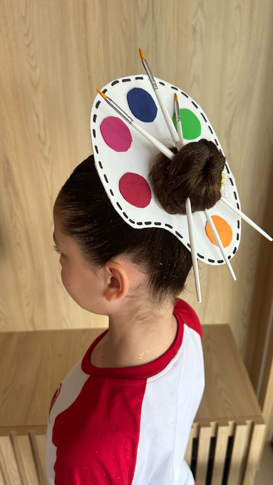 Penteado com paleta de pintura e pincéis no coque