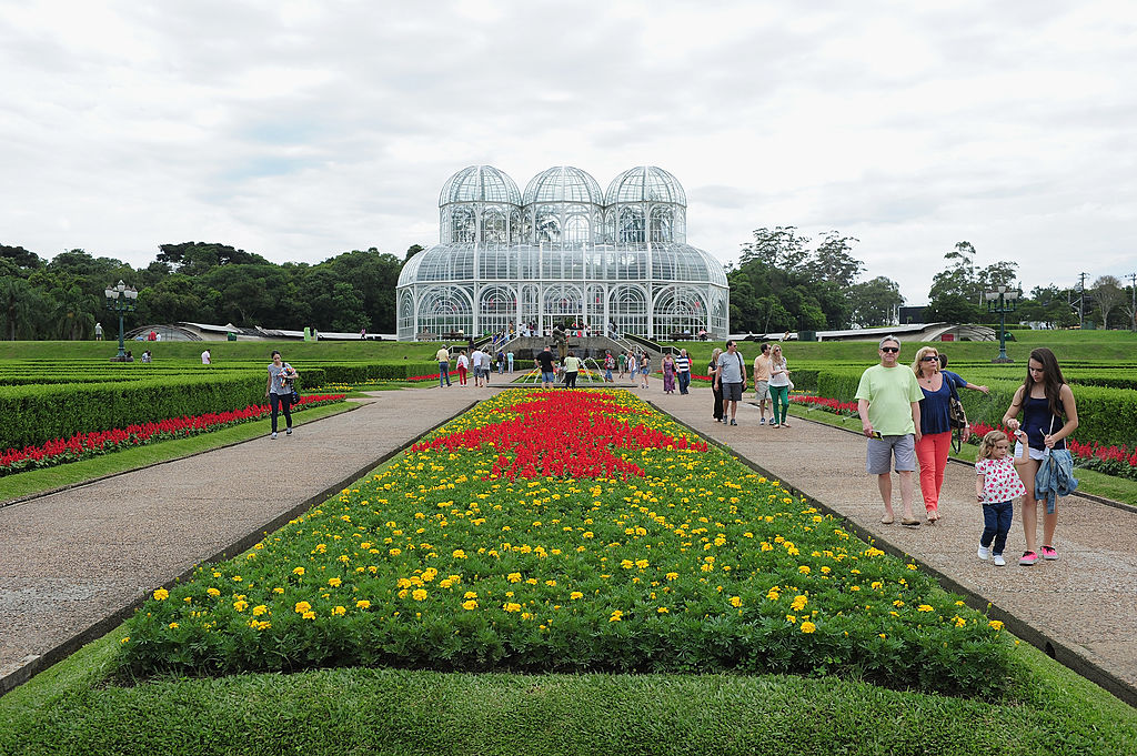 Imagem de jardim com flores e prédio de vidro