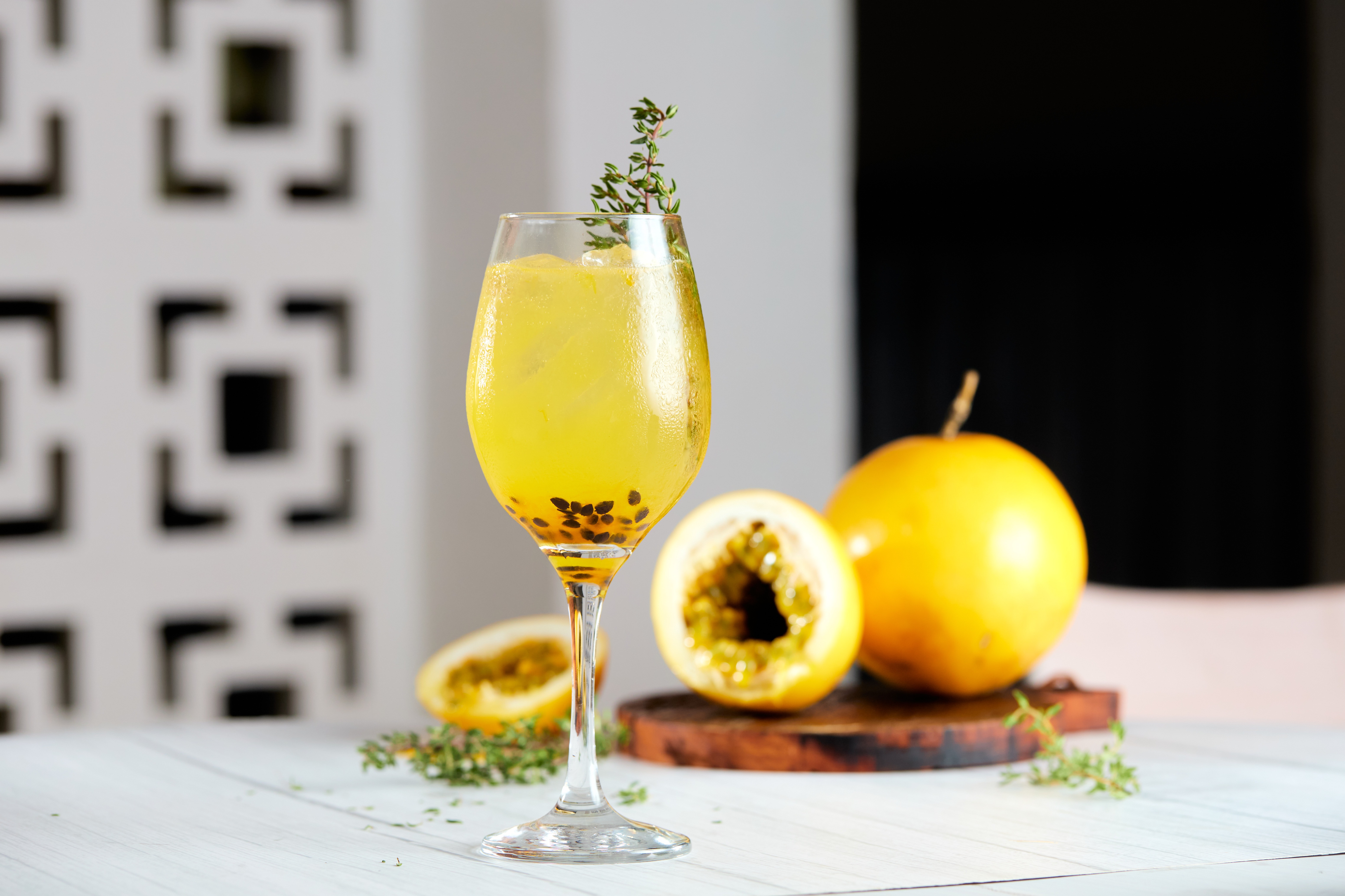 Imagem de taça de drink ao lado de um maracujá