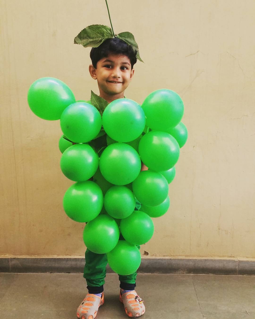 Fantasia infantil de uva feita com balões verdes