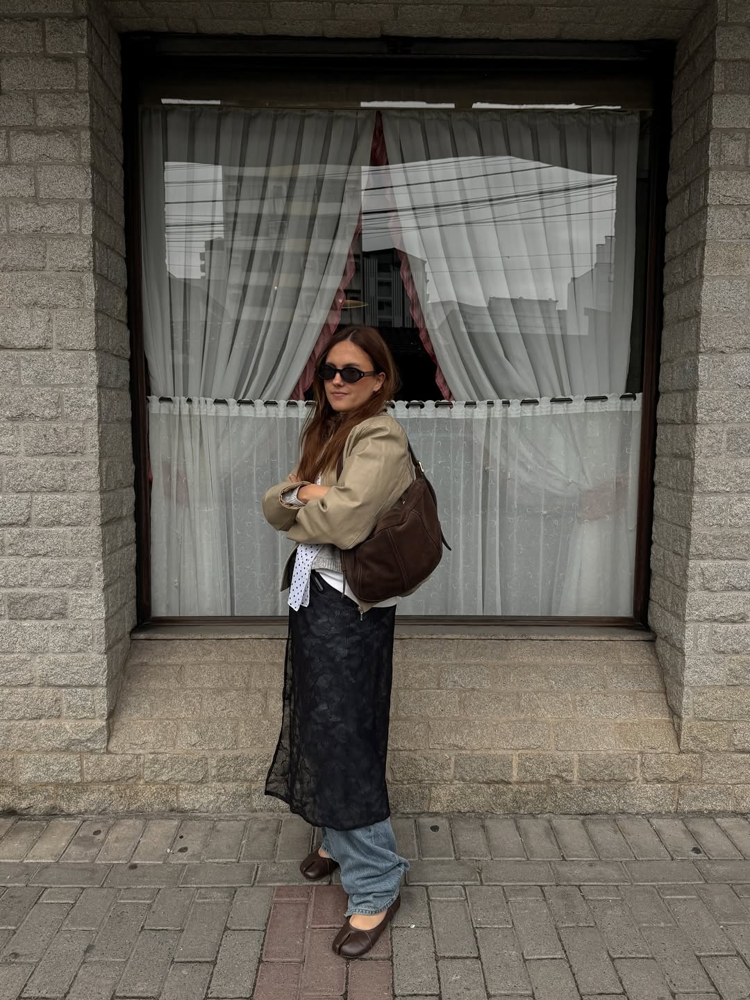 Saia de renda preta sobre calça jeans para um look fashionista