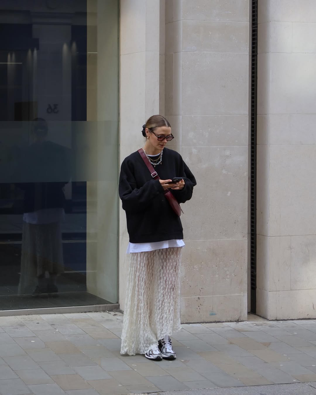 Saia de renda clara combinada com moletom oversized e tênis esportivo