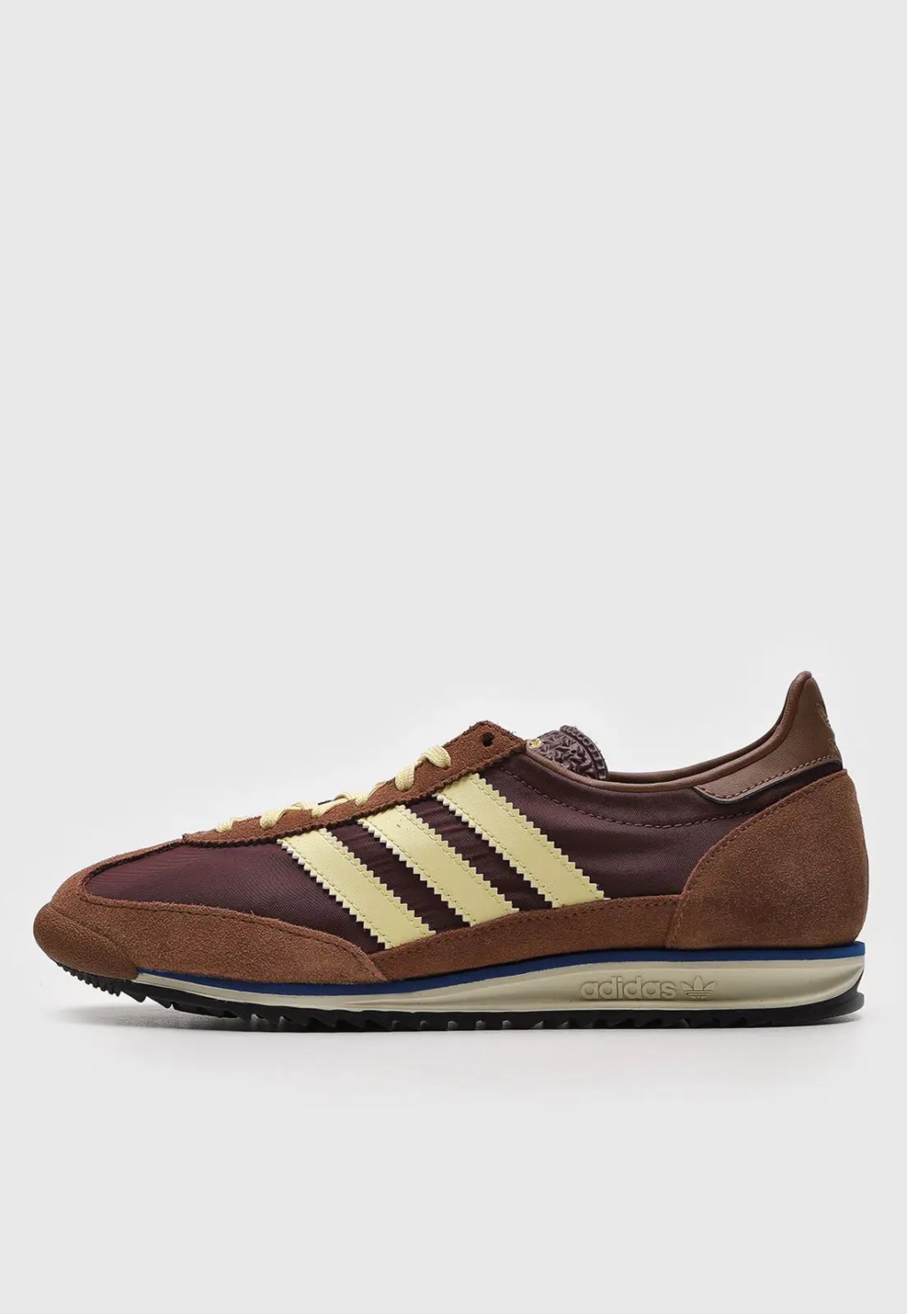 Foto de um tênis da Adidas marrom com detalhes amarelos