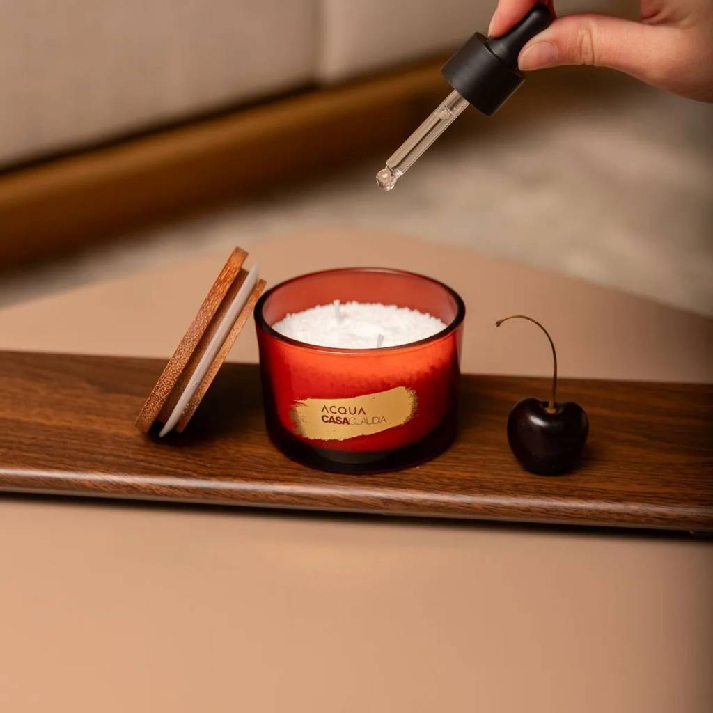 Imagem de pessoa pingando com conta gotas na vela aromática cherry red de acqua aroma