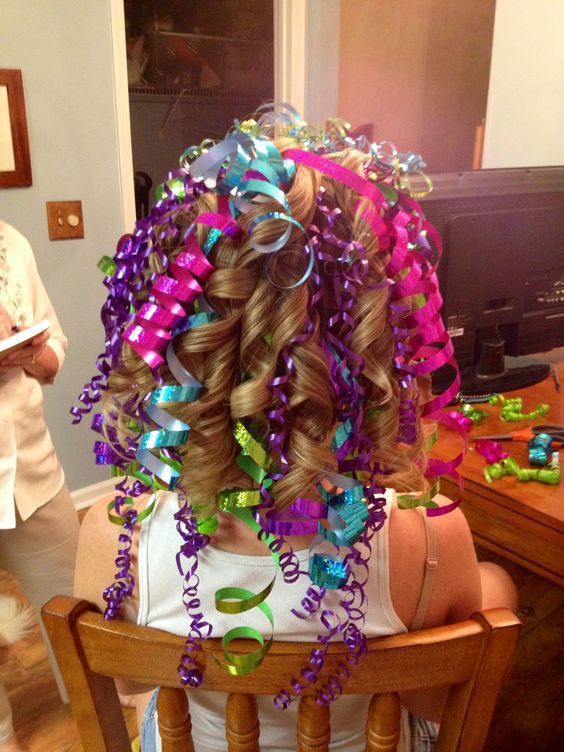 Cabelo cacheado com fitas coloridas e efeito de festa