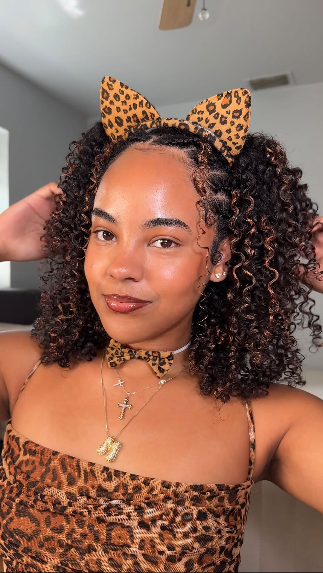 Penteado de gatinha cacheada com acess&oacute;rios de oncinha para o Halloween