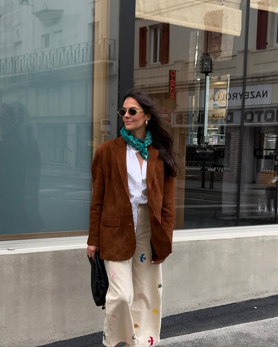Look com blazer, camiseta, calça com estampa bordada, lenço verde e óculos de sol