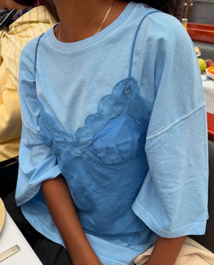 Look monocromático azul com camiseta oversized e top rendado