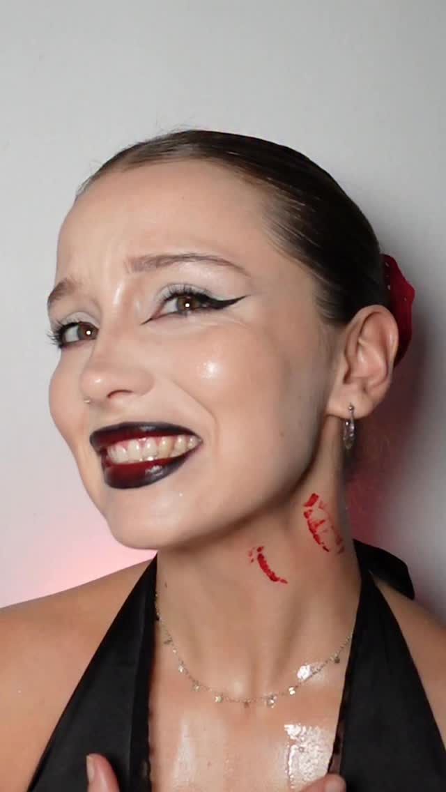 Maquiagem de vampira com batom escuro e mordida falsa para o Halloween