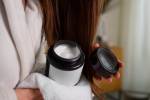 5 máscaras de cabelo que dão hidratação de salão sem sair de casa Foto de uma mulher segurando uma máscara de cabelo ao lado de seu cabelo