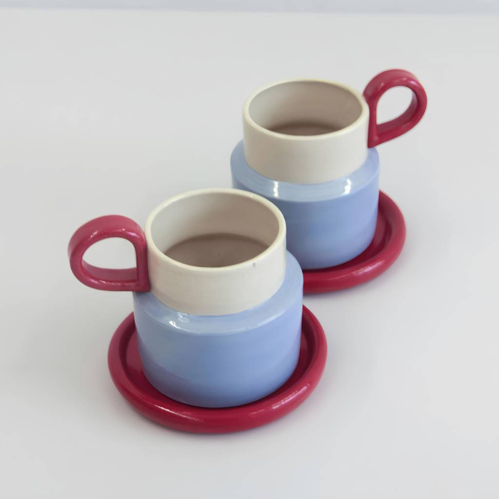 Duas canecas nas cores azul, bege e rosa.