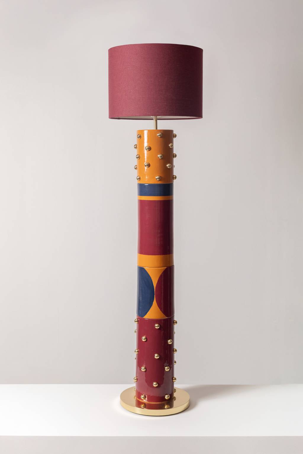 Luminária-escultura de chão. Formato pela sobreposição de peças em cerâmicas feitas no torno e pintadas manualmente