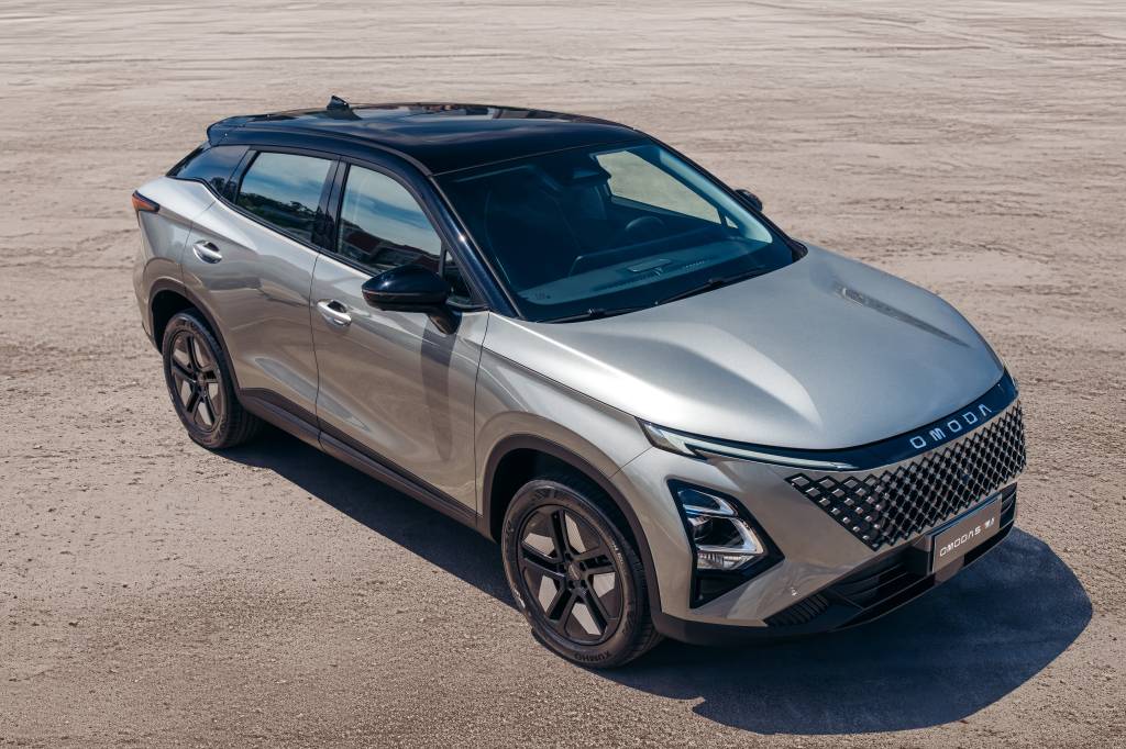 Foto do Omoda 5 em tom prata, visto de cima e de lado, estacionado em área ampla e clara. O SUV destaca linhas modernas, grade frontal marcante e teto preto. A imagem ilustra o test-drive do modelo em São Paulo, ressaltando design, conforto e recursos tecnológicos