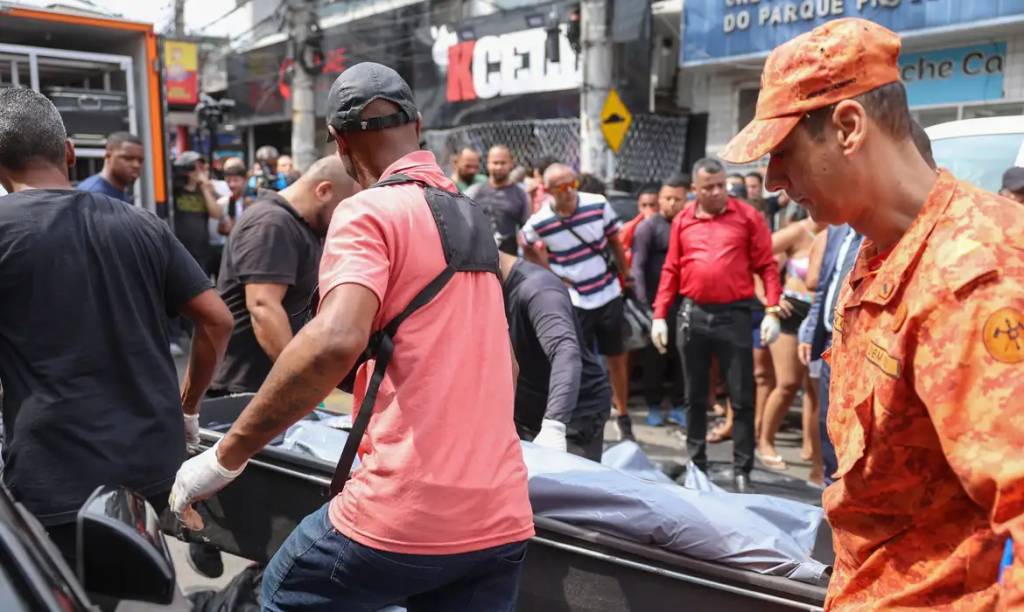 Foto de um homem com uma camiseta vermelha e uma mini mochila preta
