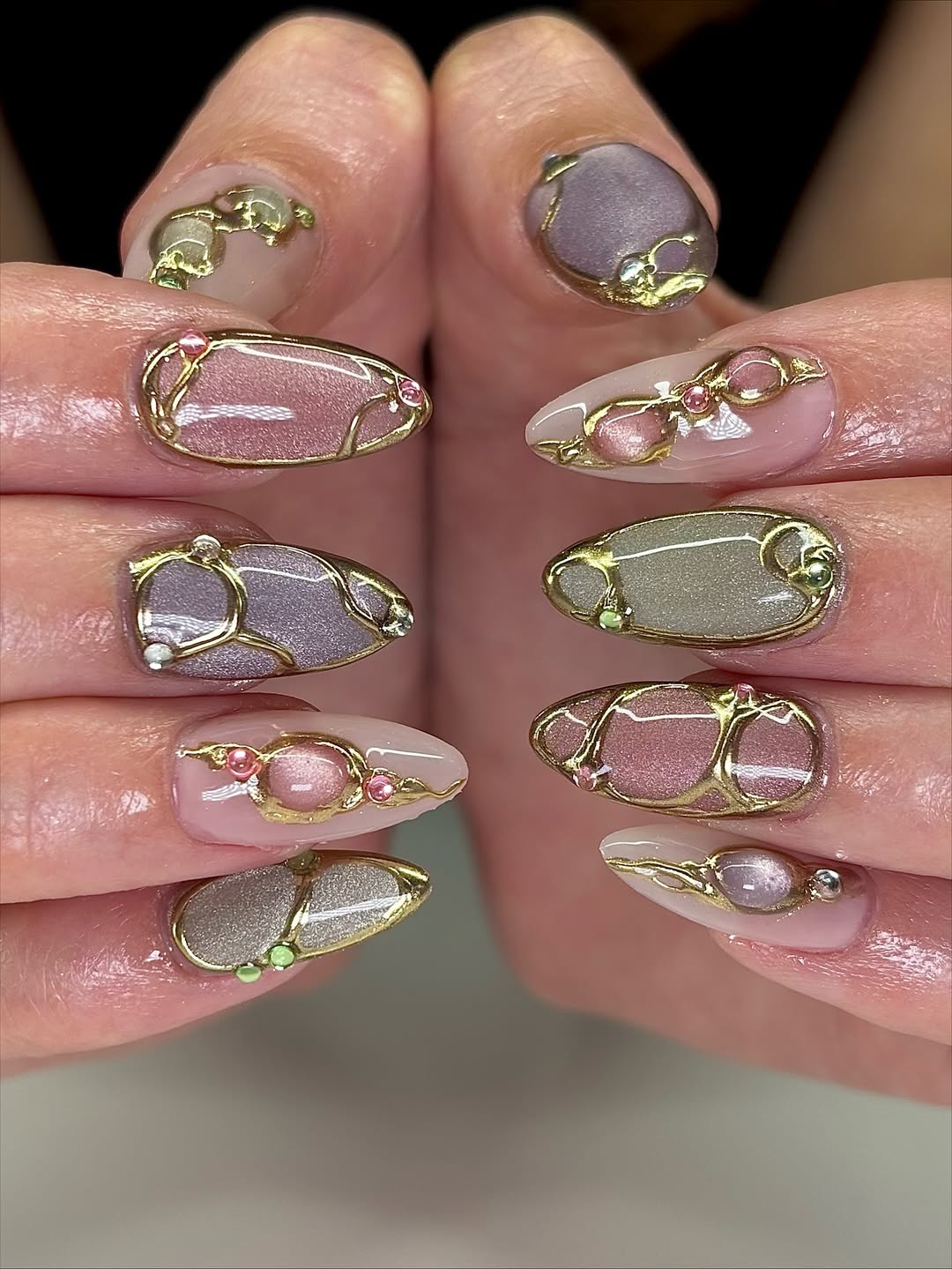 Unhas acrigel em tons perolados com detalhes dourados e pedrarias