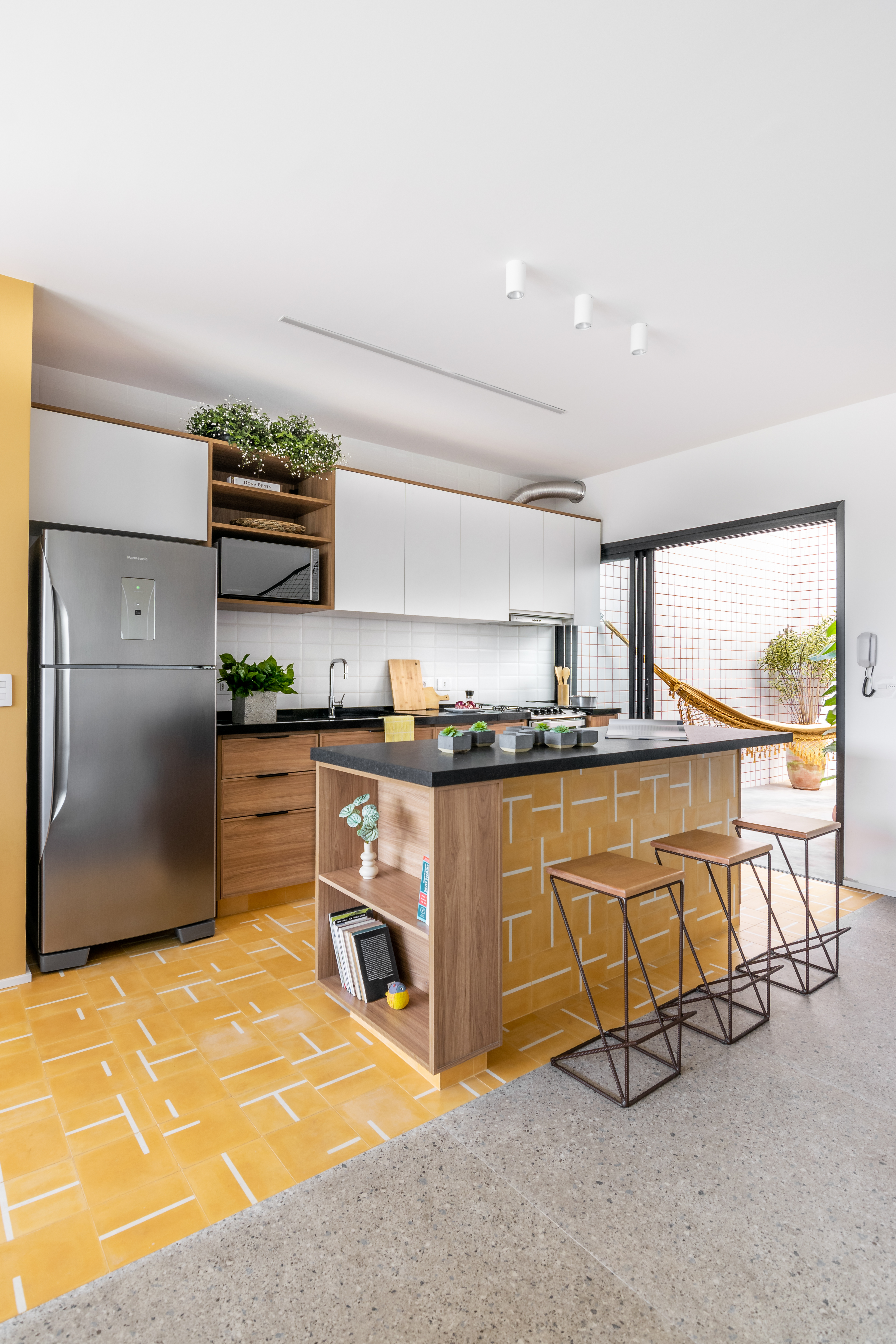 Cozinha pequena com ilumina&ccedil;&atilde;o natural e piso amarelo vibrante.