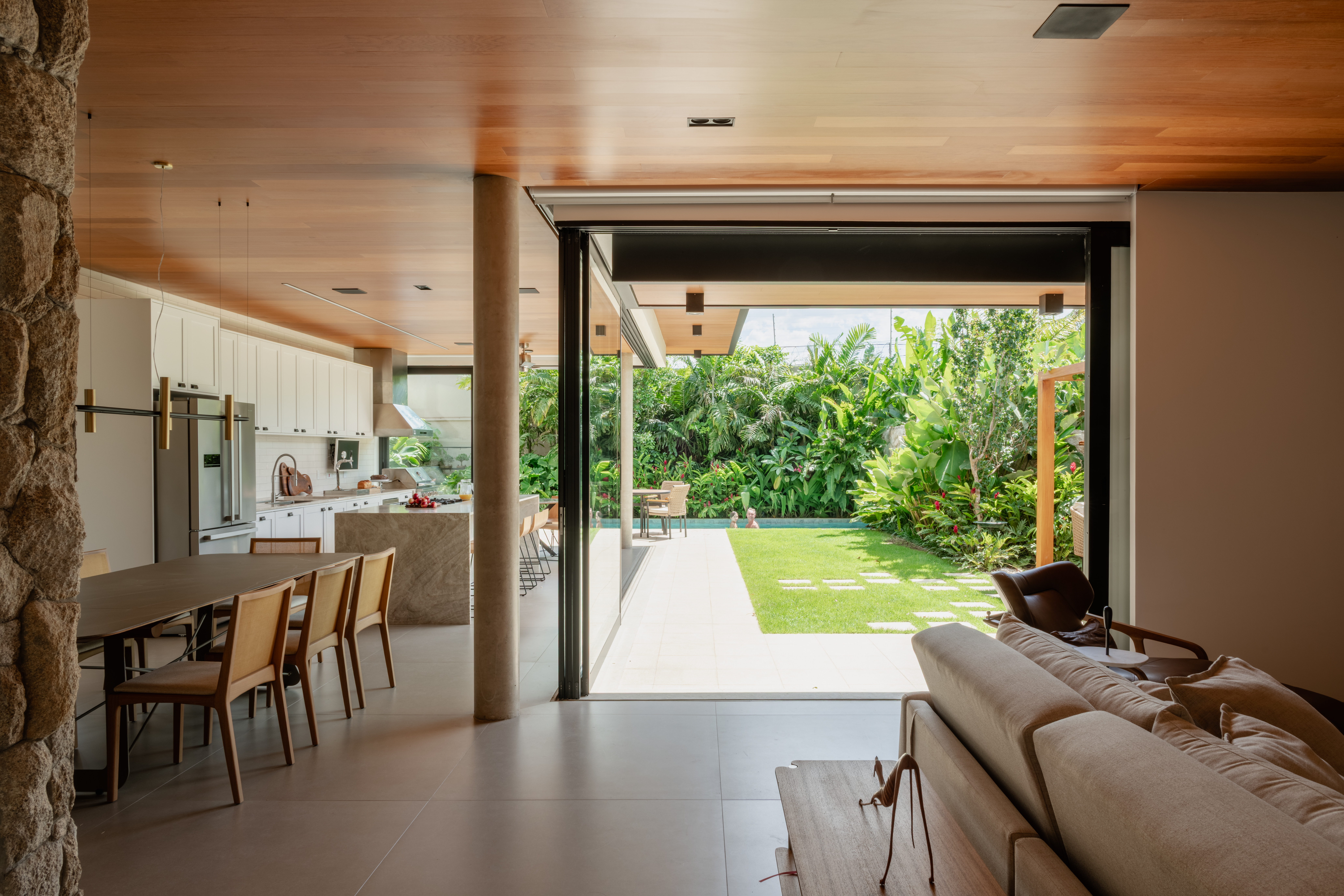 Sala de estar, cozinha e quintal integrados por amplas portas de correr