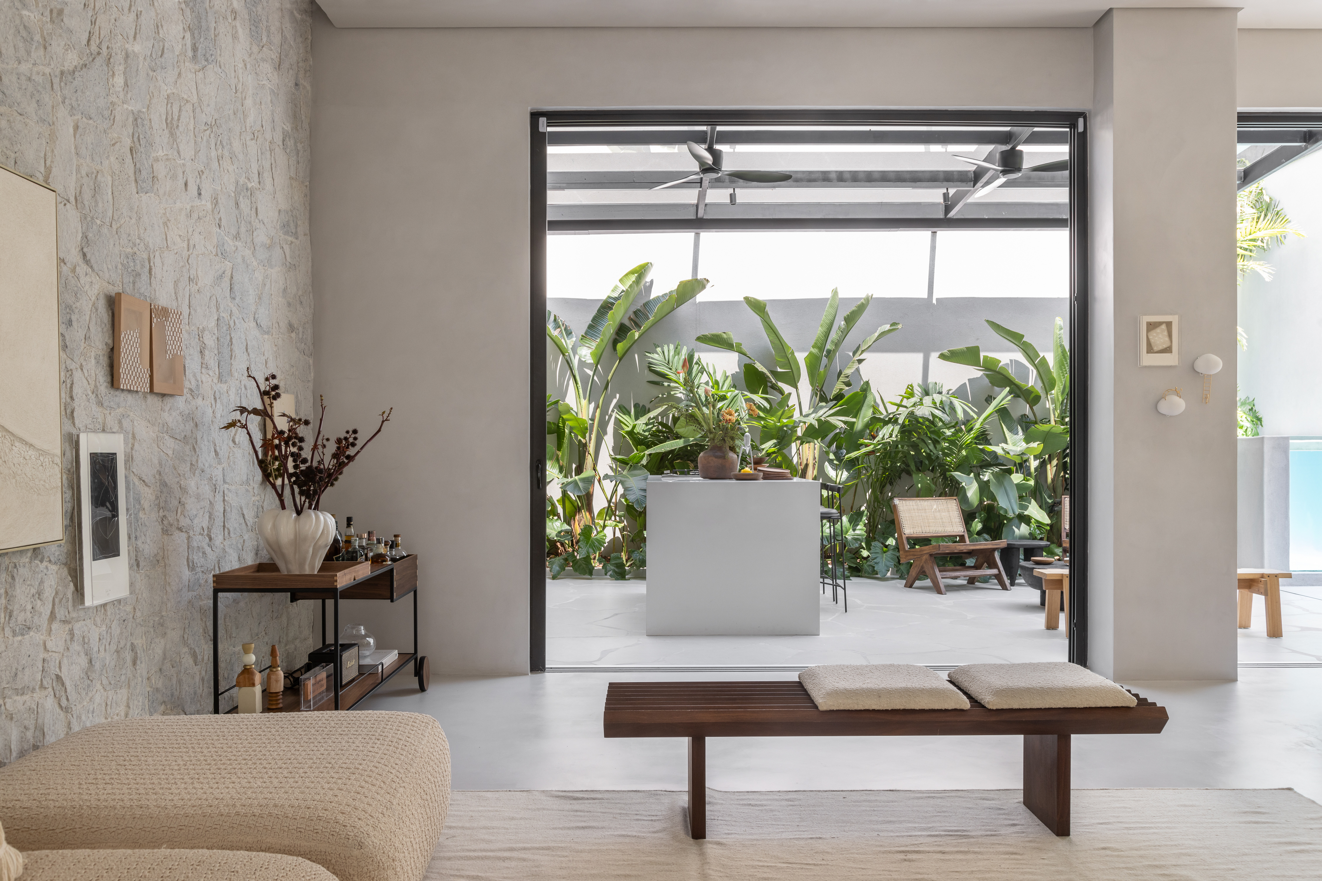 Sala de estar integrada com &aacute;rea externa em casa com estilo praiano