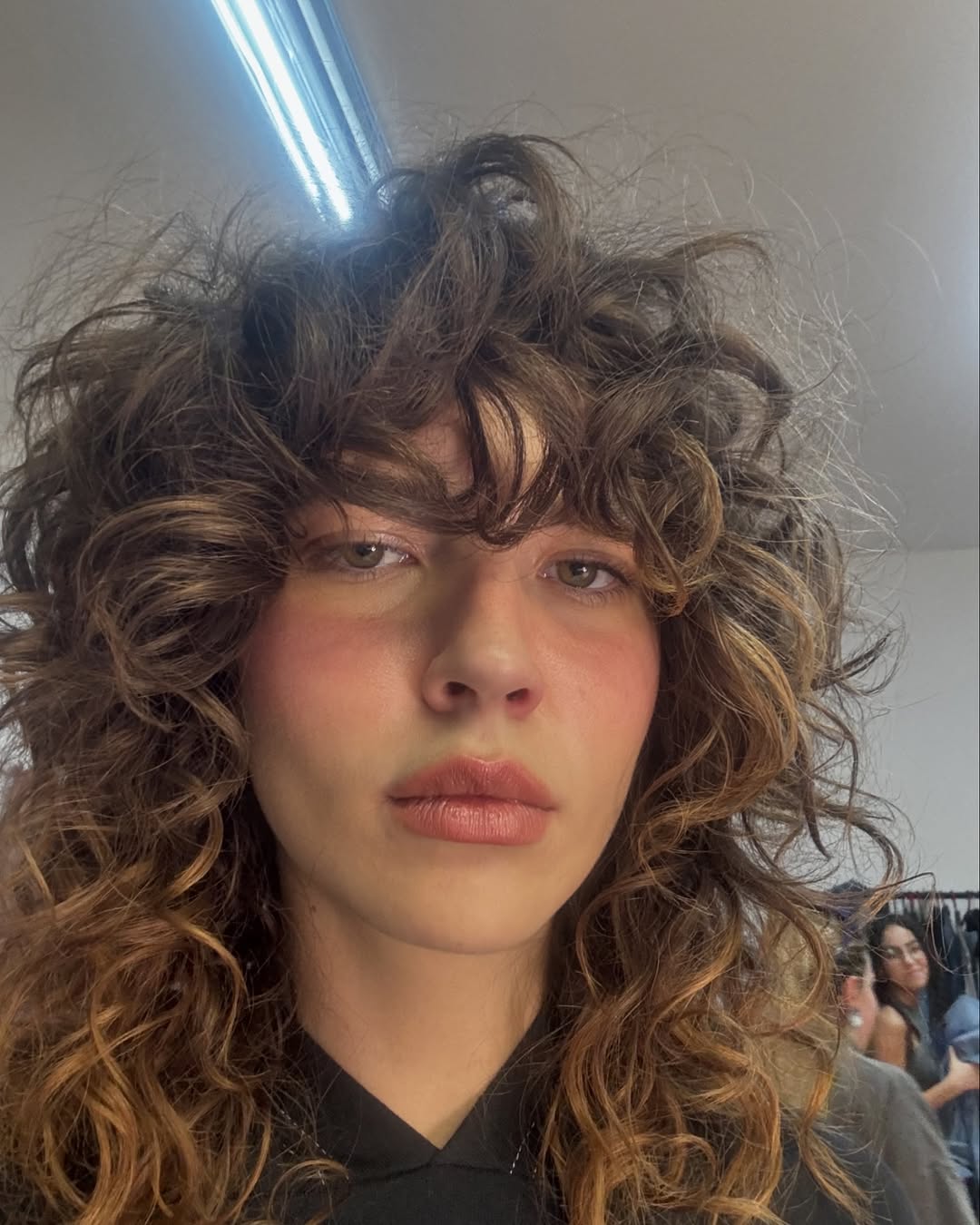 Selfie de mulher tirada de baixo com o cabelo cacheado despojado