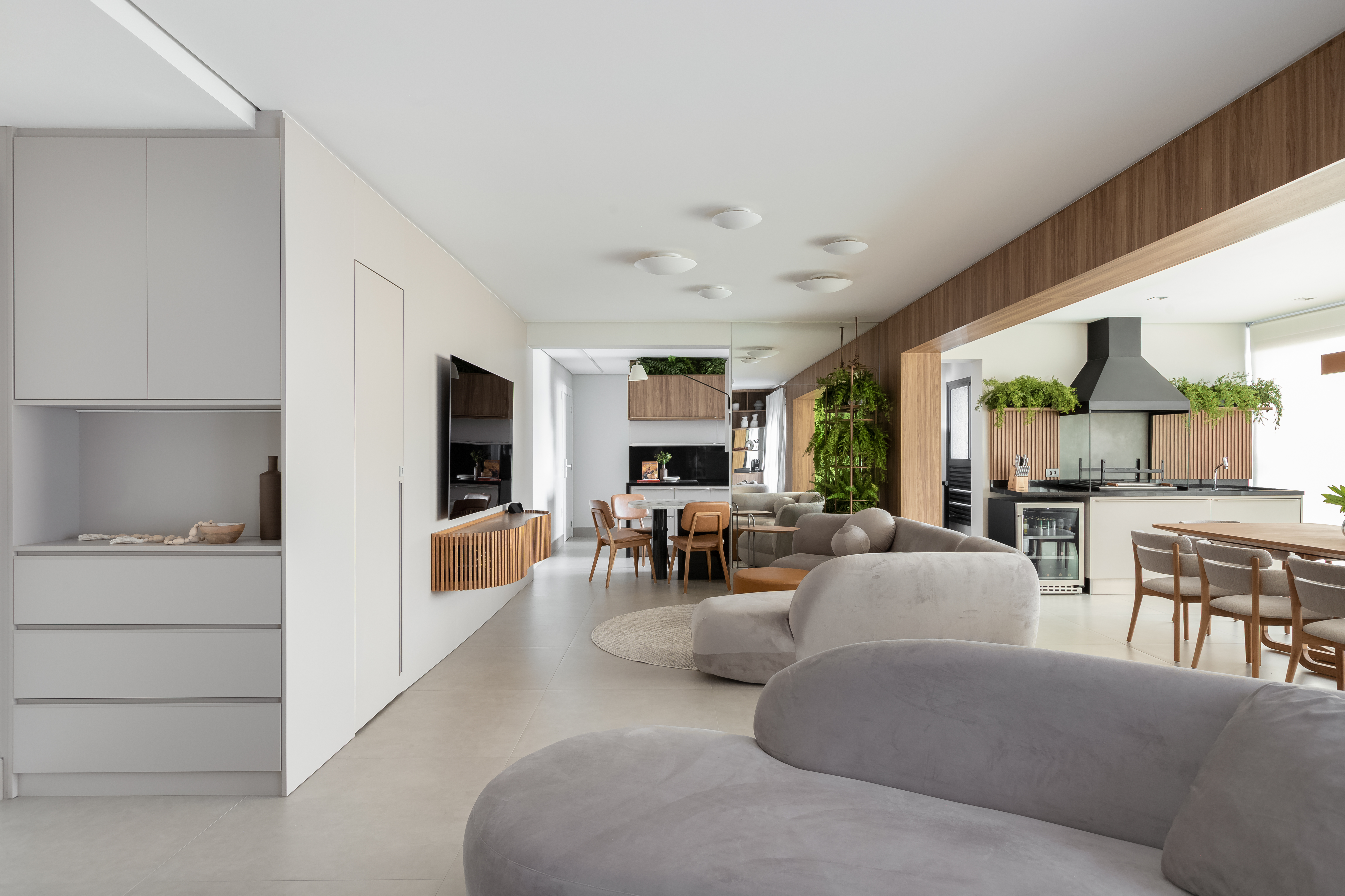 Sala de estar com sof&aacute;s em formatos org&acirc;nicos e cores neutras