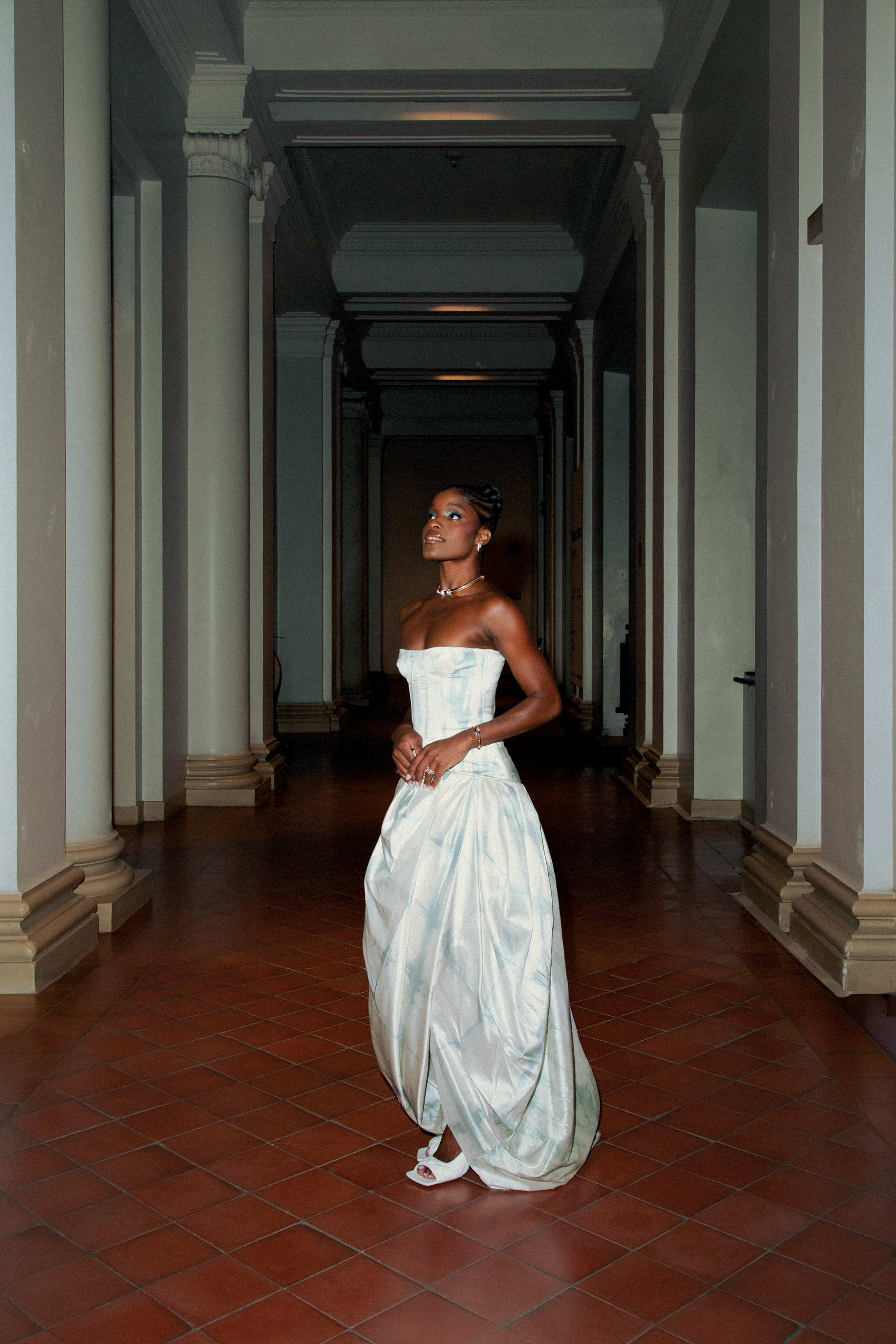 Foto de Ingrid Silva. Ela &eacute; negra, est&aacute; usando um coque no cabe&ccedil;o e um vestido branco sem al&ccedil;as, al&eacute;m de joias