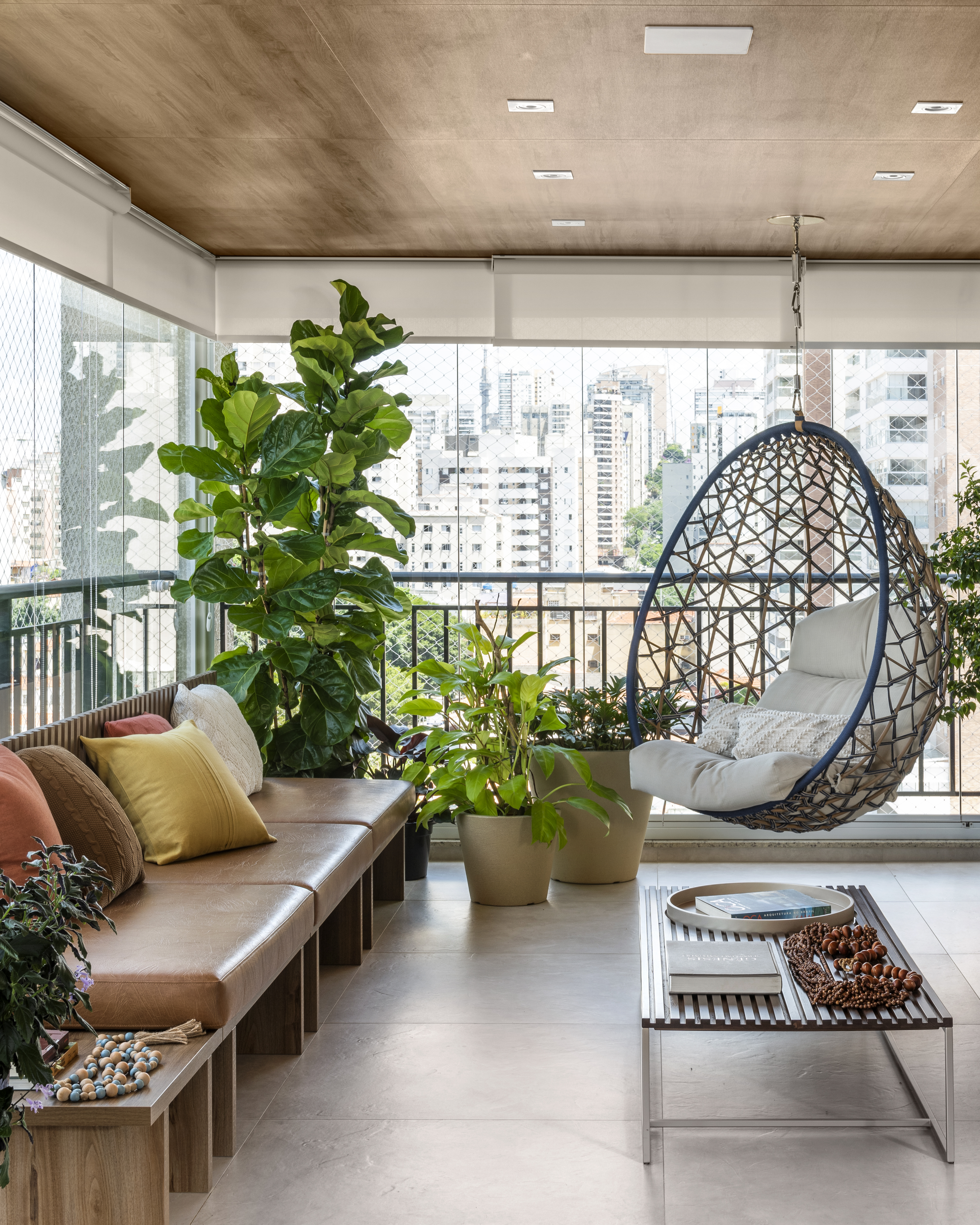 Varanda com janela de parede a parede, revestida com materiais naturais