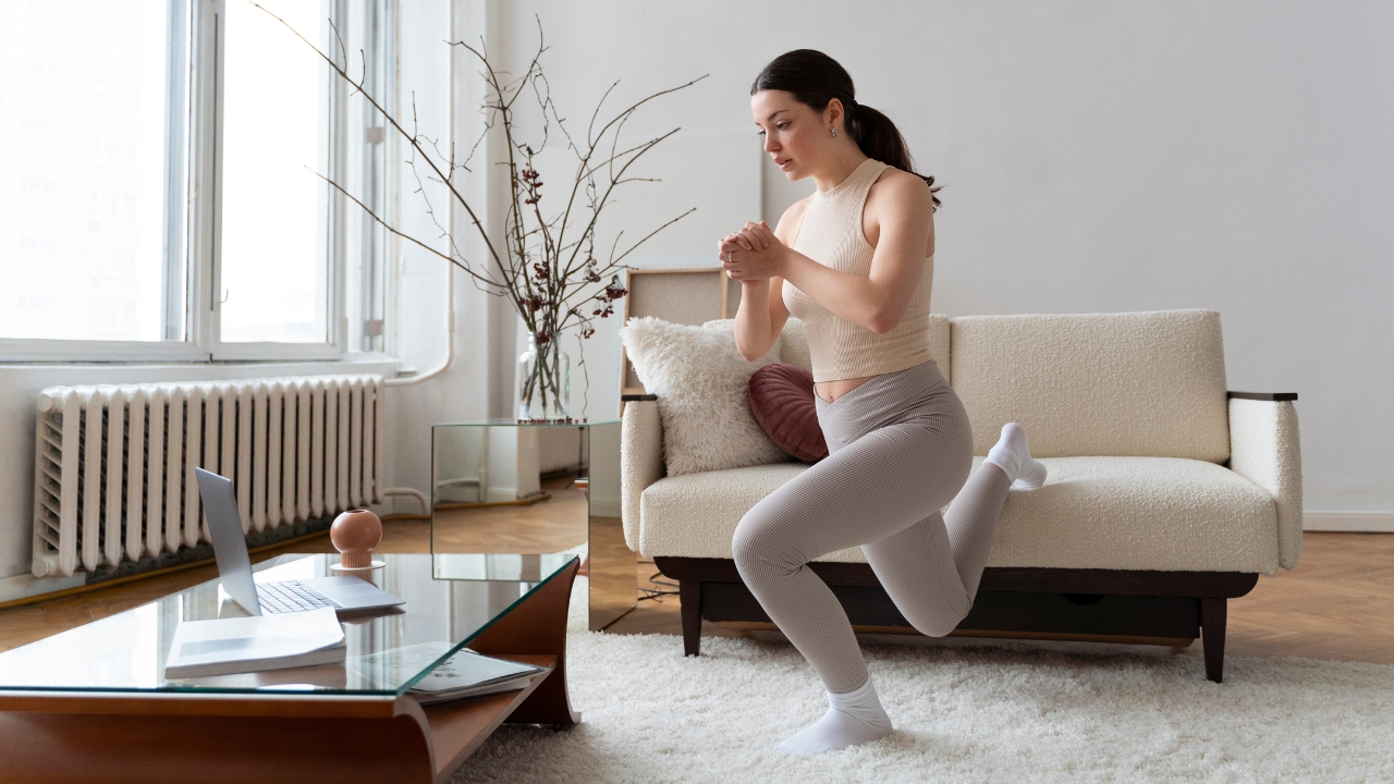 Mulher fazendo exercícios na sala de casa apoiando no sofá