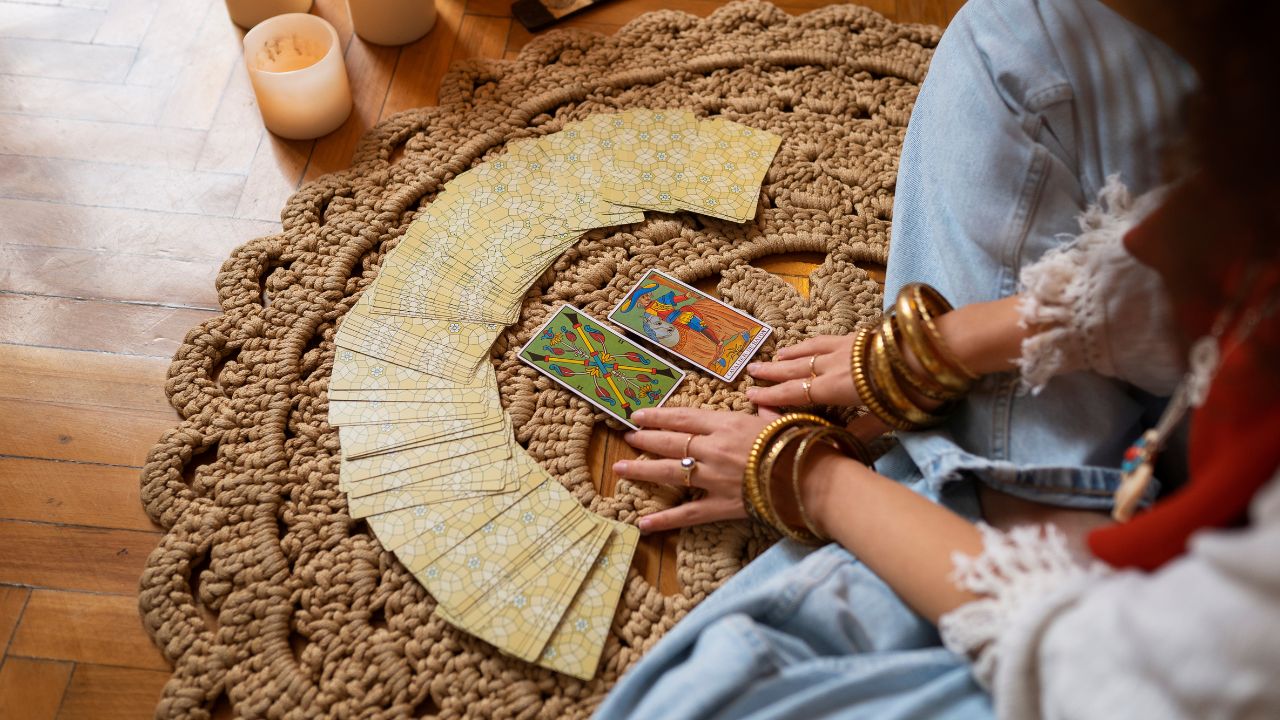 Mulher sentada no chão com cartas à frente tirando tarô