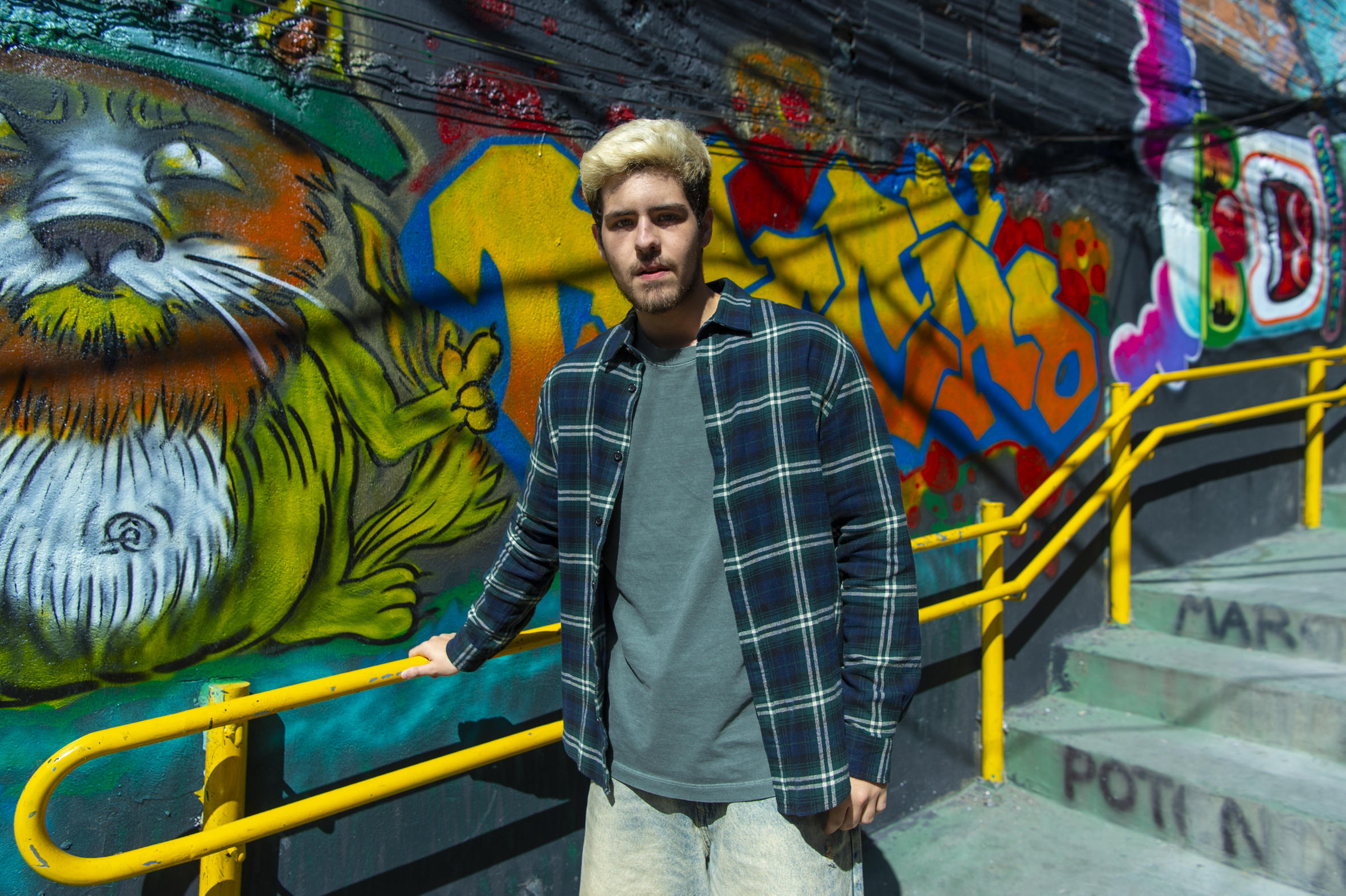 Cena de Três Graças mostra Raul diante de um mural de grafite em uma escadaria da comunidade, no capítulo 72 (10/01), marcado por ligações dizendo que ele morreu e pela tensão envolvendo Ferette, Zenilda e a investigação da estátua As Três Graças