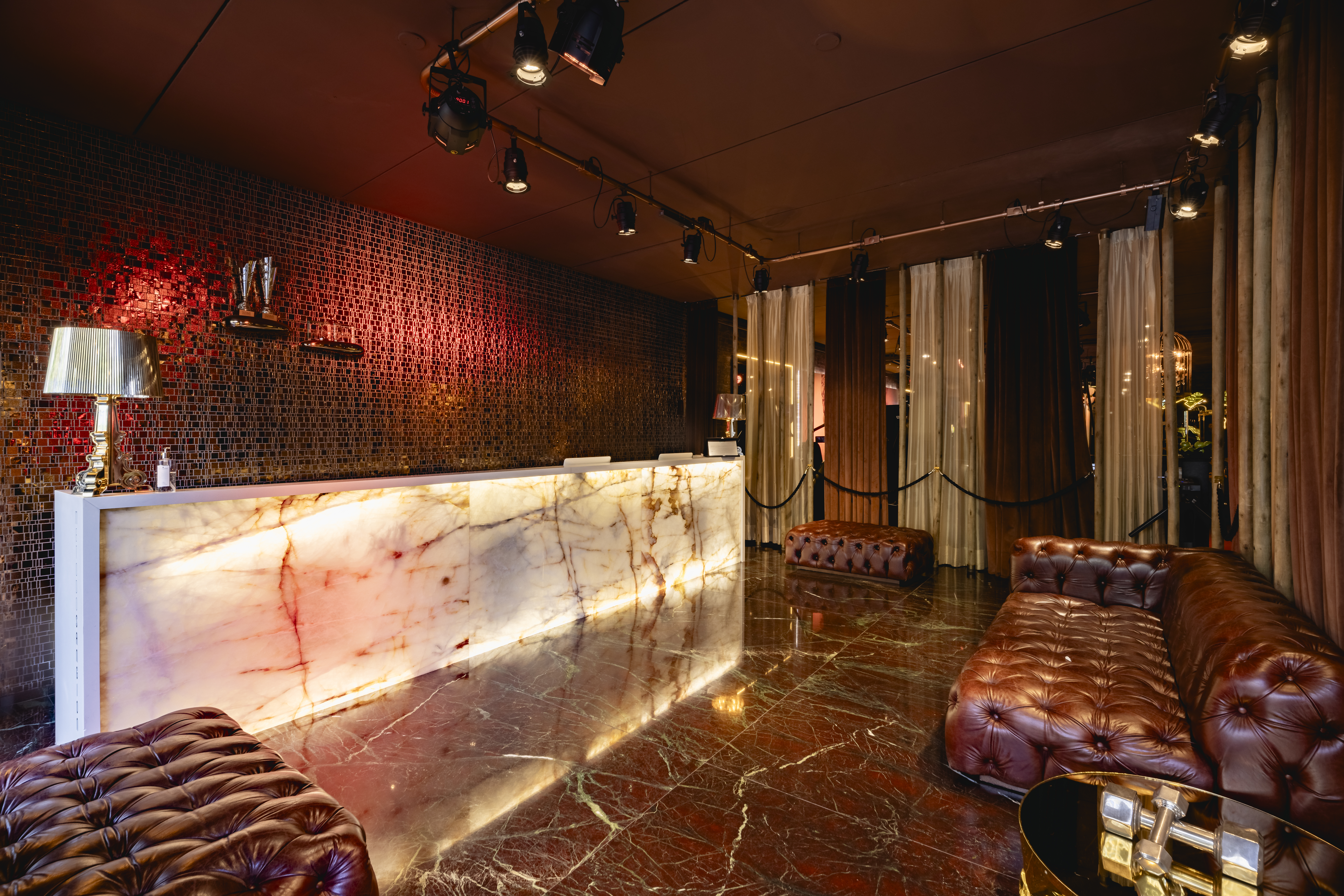 Recep&ccedil;&atilde;o luxuosa com bancada de m&aacute;rmore iluminada e bancos de couro