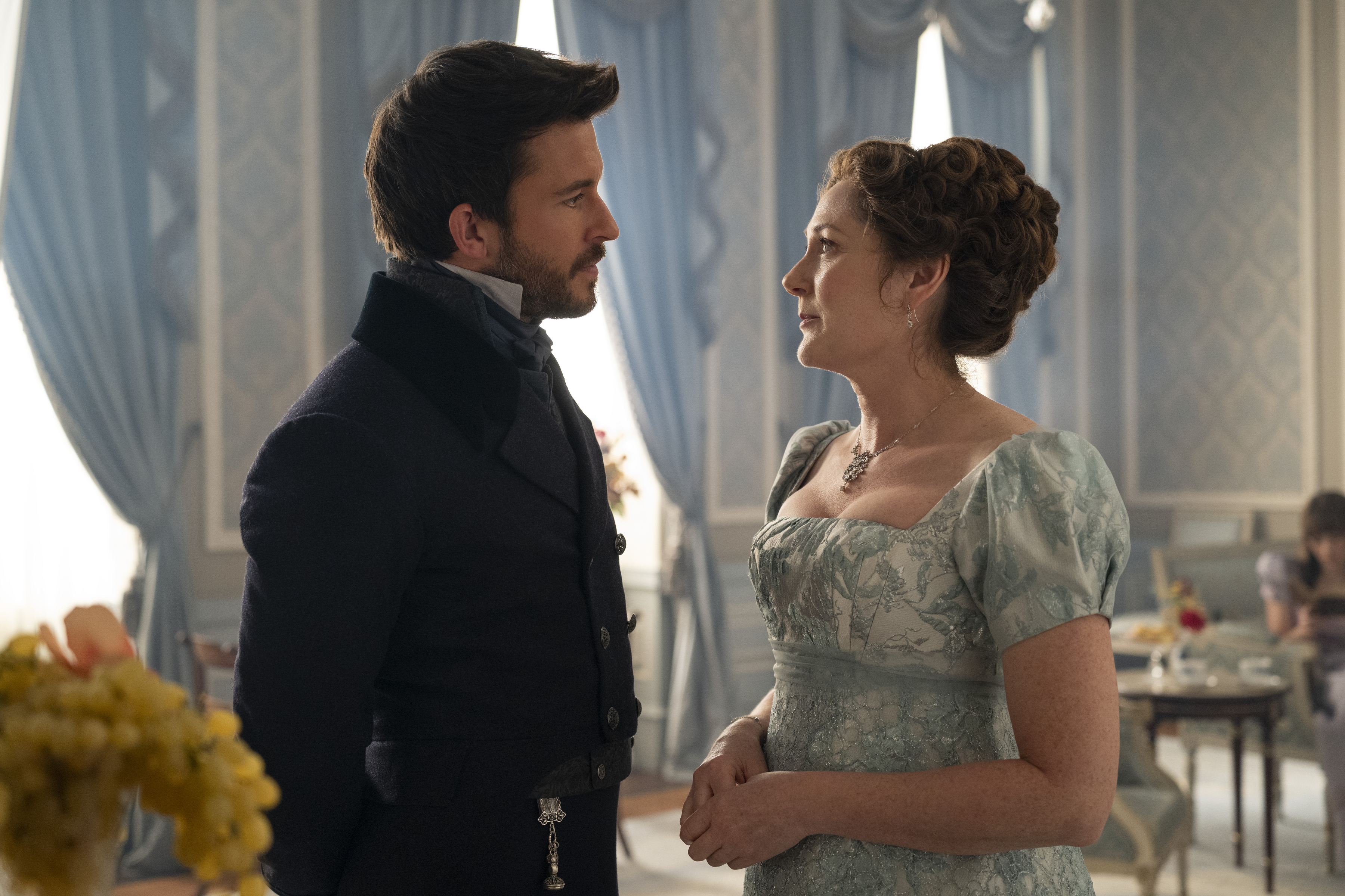 M&atilde;e e filho conversam em um elegante sal&atilde;o azul, em um encontro que promete tens&atilde;o, conselhos e poss&iacute;veis reviravoltas familiares.