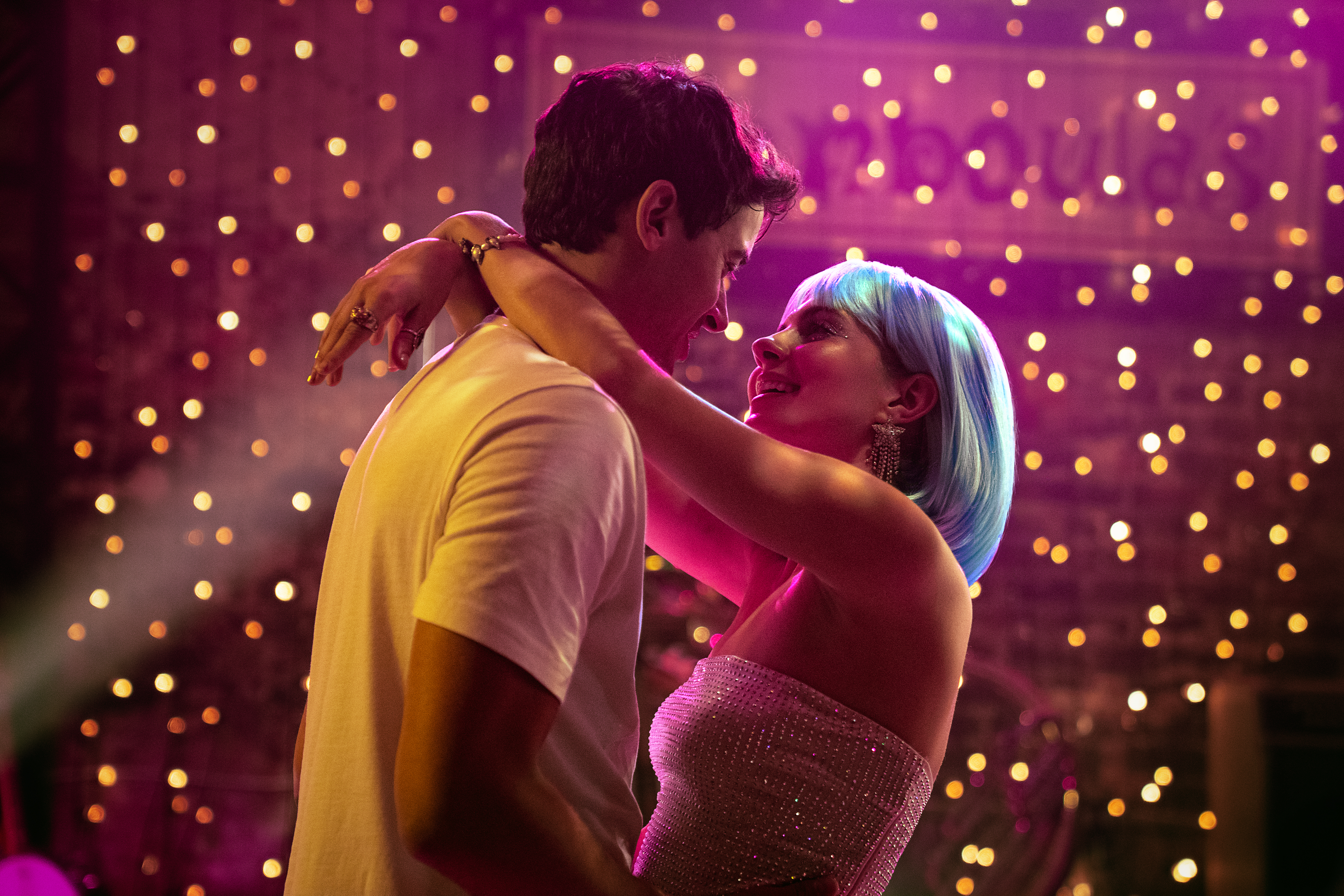 Poppy e Alex se abra&ccedil;am e trocam olhares em pista iluminada, cena do filme People We Meet on Vacation da Netflix, romance contempor&acirc;neo inspirado no livro de Emily Henry que explora desejo, sil&ecirc;ncio e amizade.