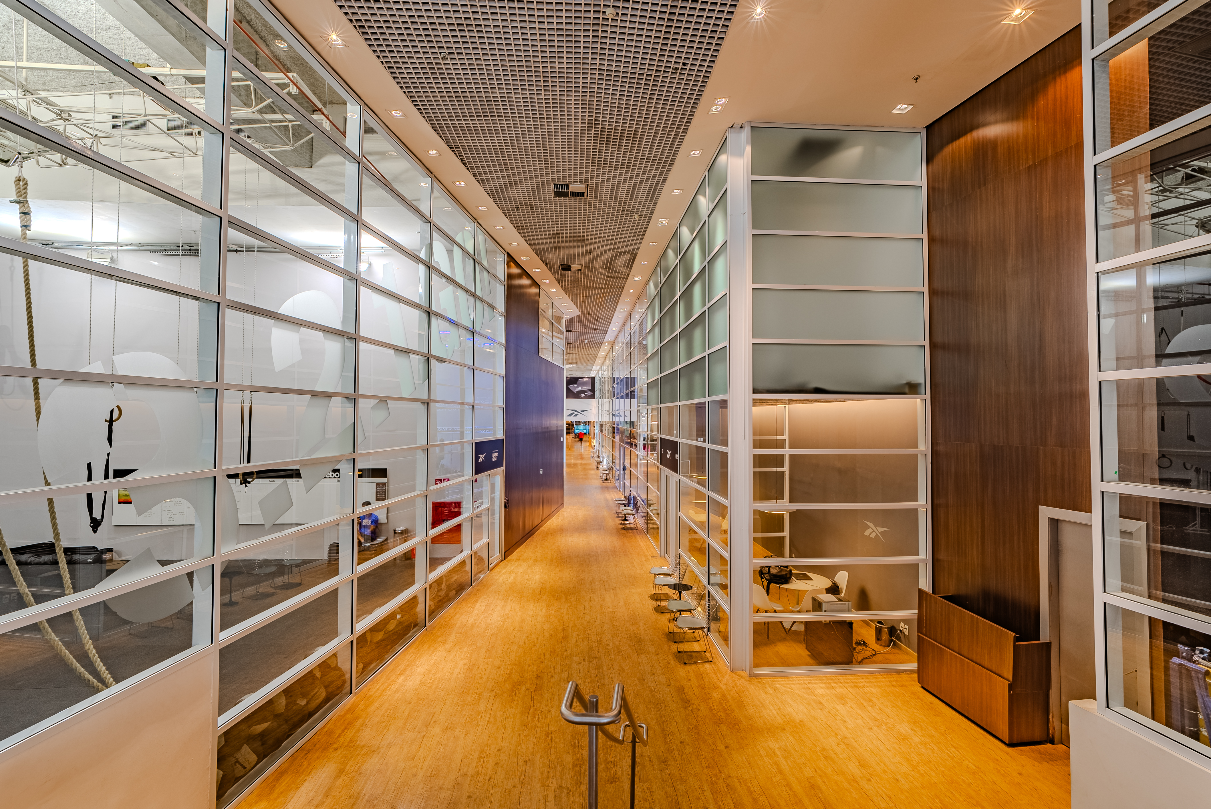 Corredor com janelas de vidro com p&eacute; direito duplo