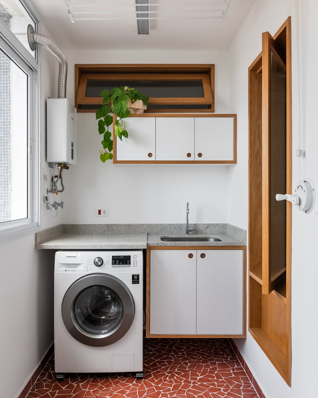 Lavanderia com piso de caquinho vermelho e arm&aacute;rios brancos