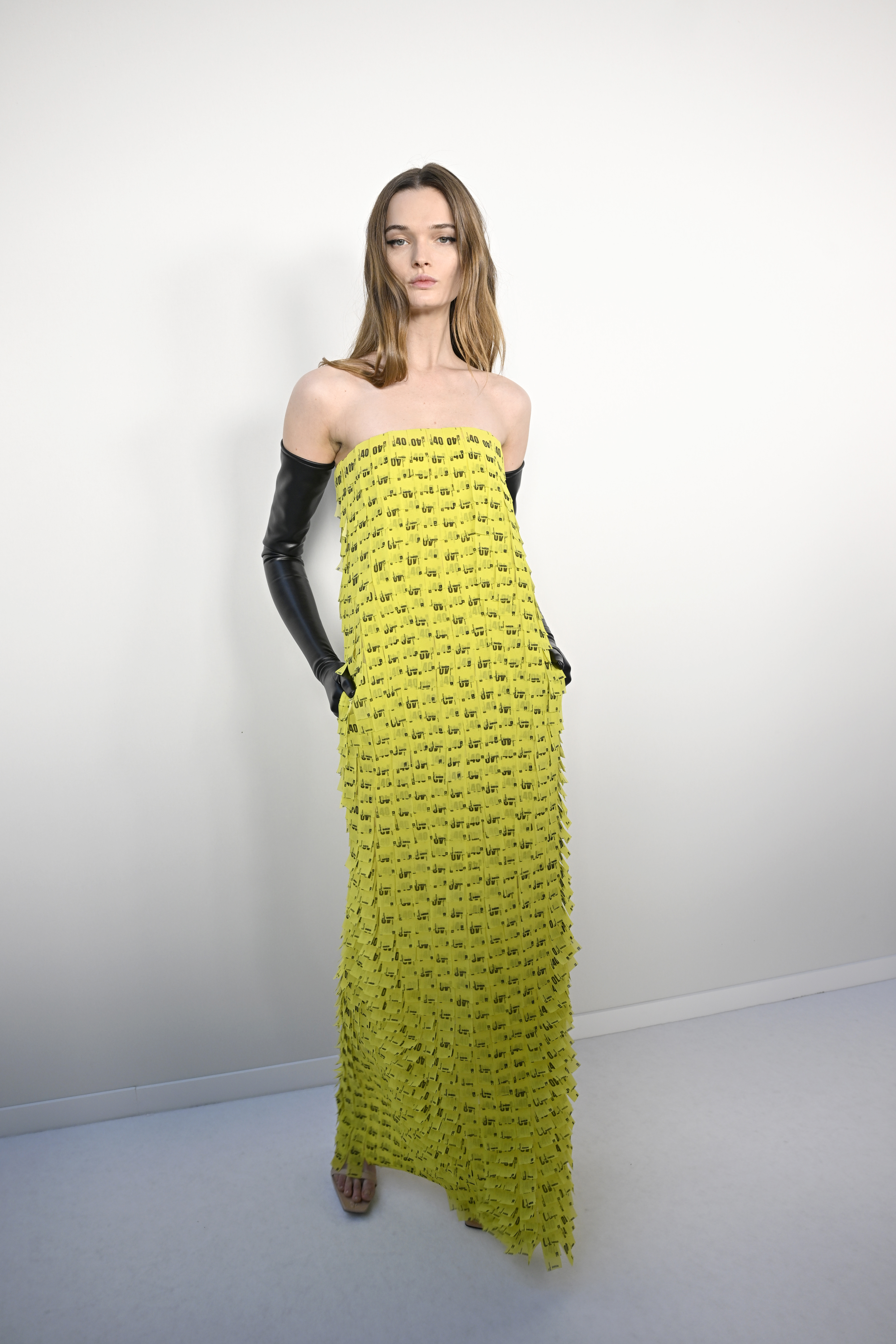 Modelo posando com look feito de bilhete de metro amarelo