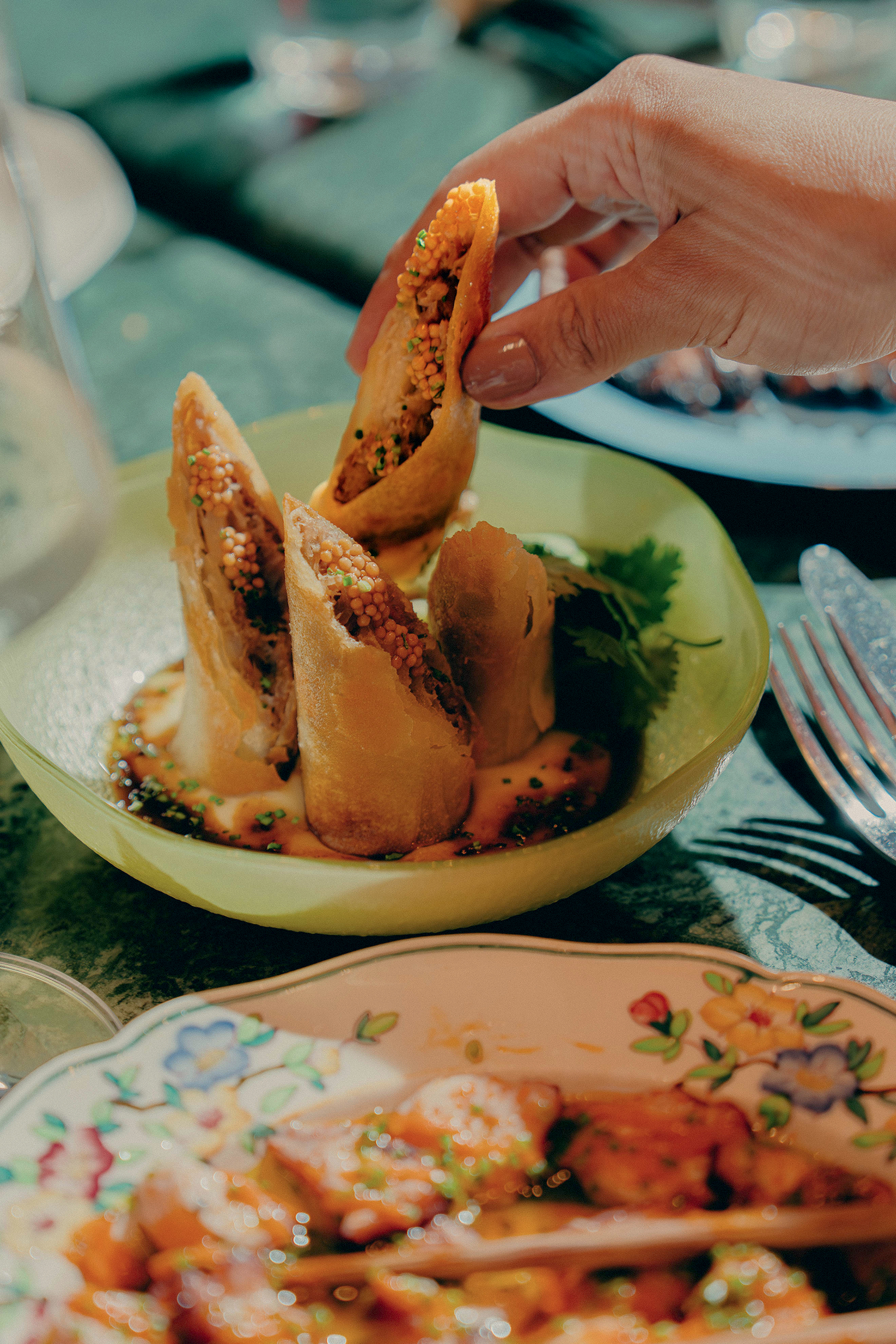 Harumaki de bochecha de porco do Barkatu, servido com molho e fonduta de alho, petisco sofisticado que combina t&eacute;cnicas japonesas e espanholas em restaurante de S&atilde;o Paulo.