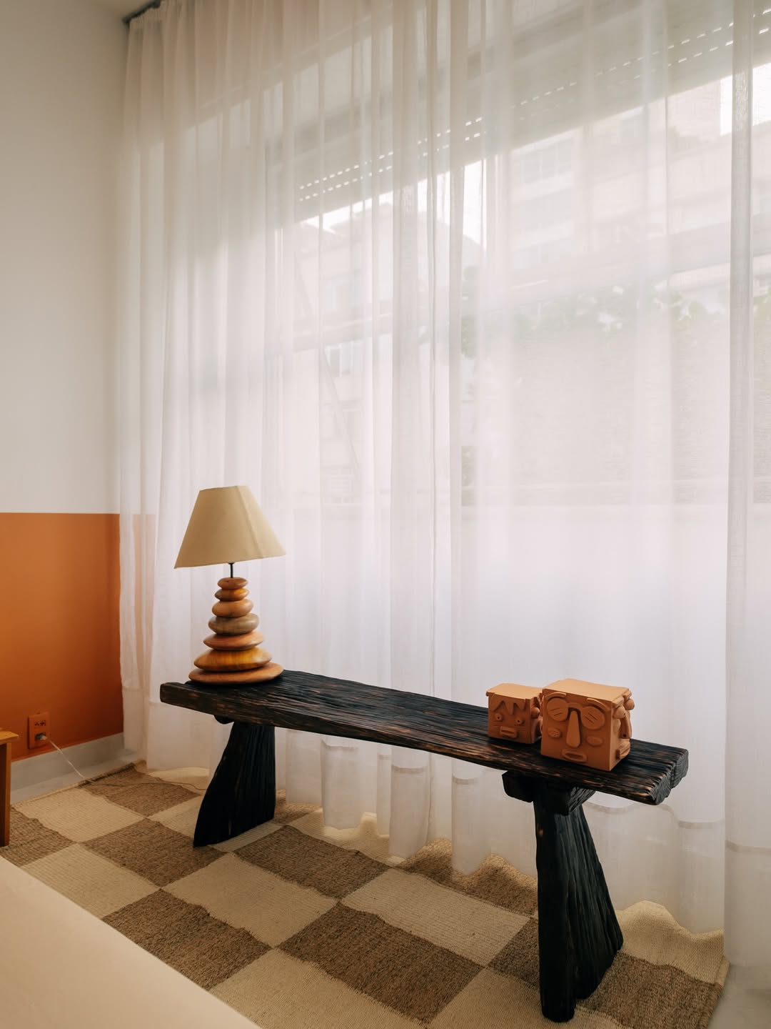 Canto de quarto decorado com abajur e banco