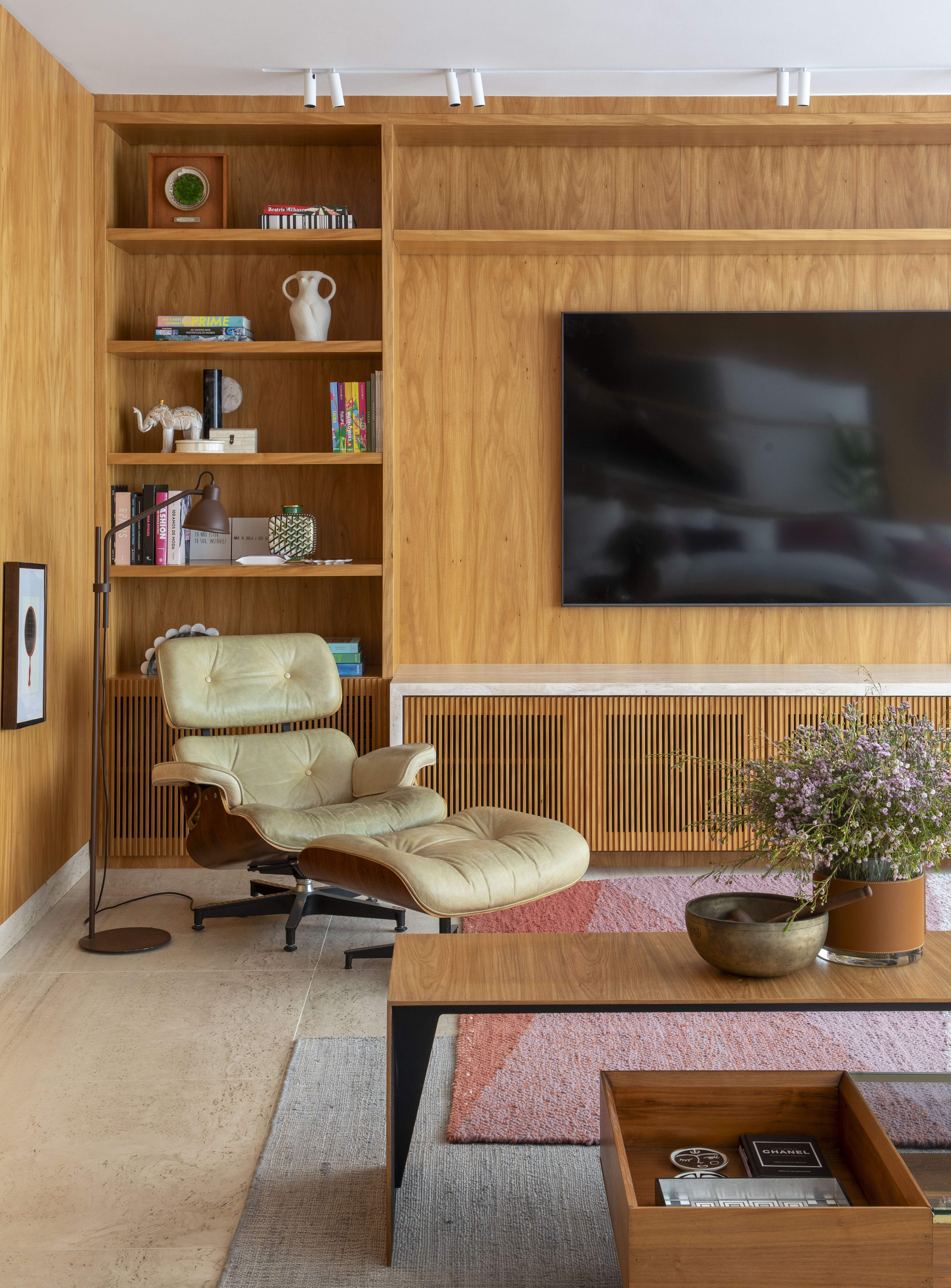 Sala de TV com cantinho de leitura e poltrona bege