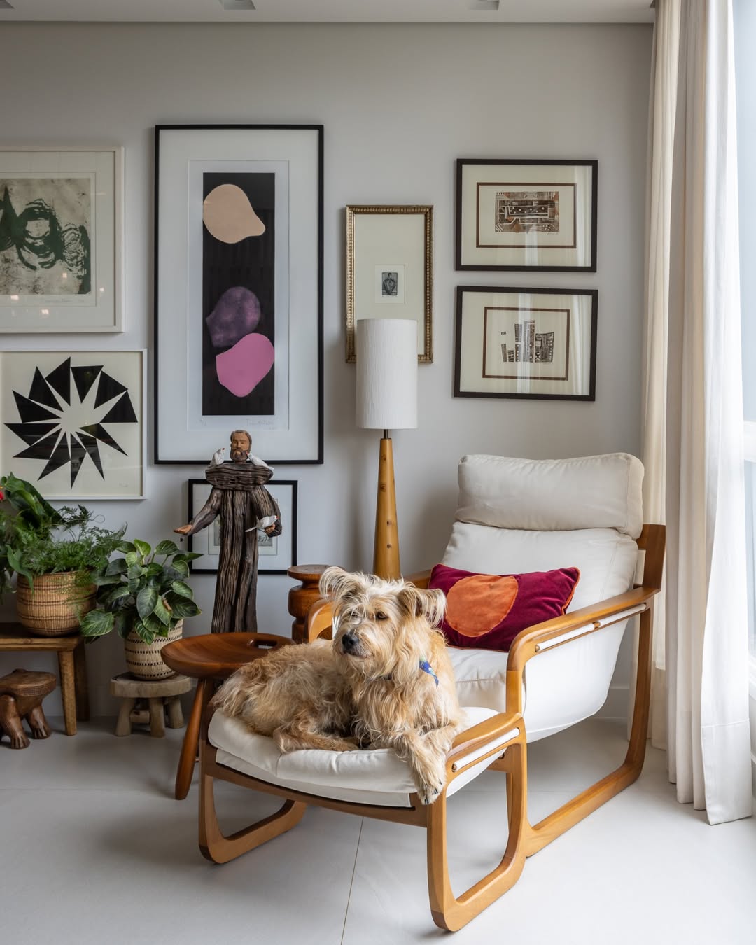 CAntinho da leitura com cachorro deitado na poltrona e decora&ccedil;&atilde;o de quadros na parede