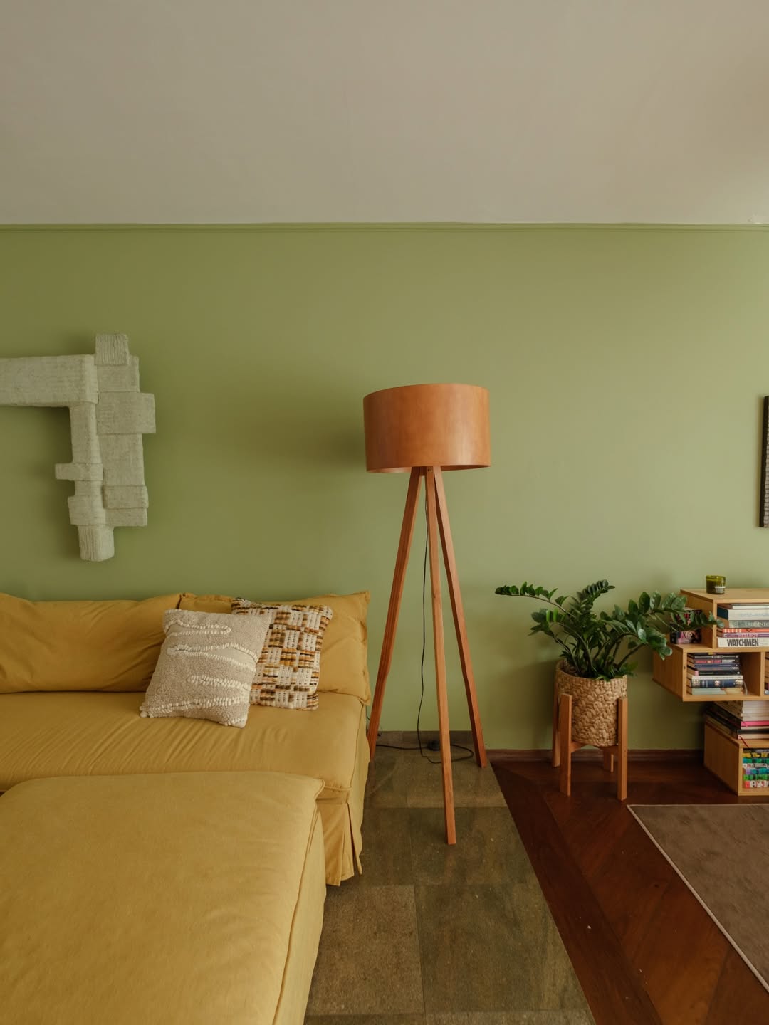 Sala de estar de parede verde com abajur de madeira de ch&atilde;o