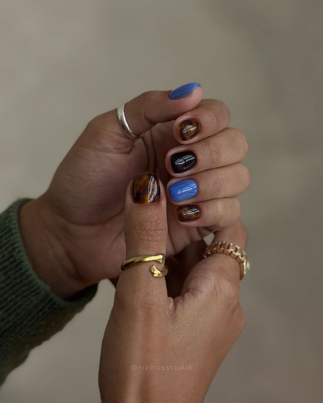 Mix de esmaltes com azul, preto e estampa marmorizada cria unhas modernas e sofisticadas