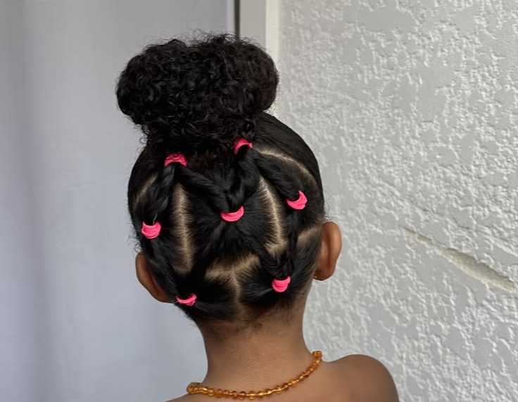 Penteado infantil com tran&ccedil;as e coque para cabelo cacheado