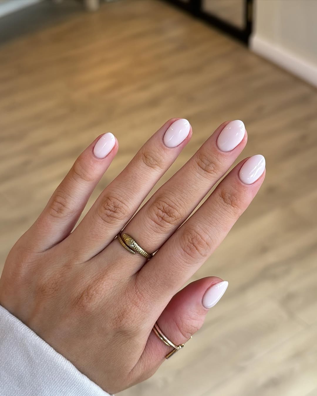 Unhas amendoadas curtas com esmalte nude cl&aacute;ssico