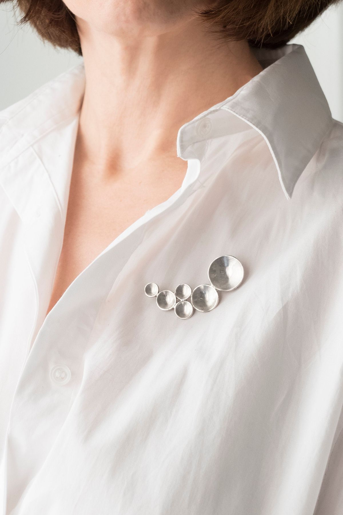 Adicionar um broche em uma jaqueta jeans, camiseta branca ou até mesmo em um conjunto neutro é uma forma simples de trazer um ar mais jovem ao visual sem precisar investir em roupas novas.