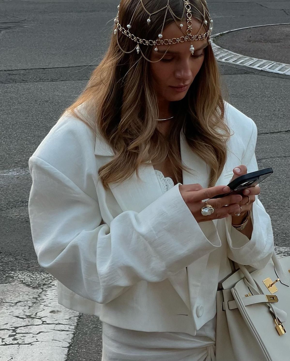 Foto de uma mulher loira usando um look composto por headpiece com brilhos e alfaiataria