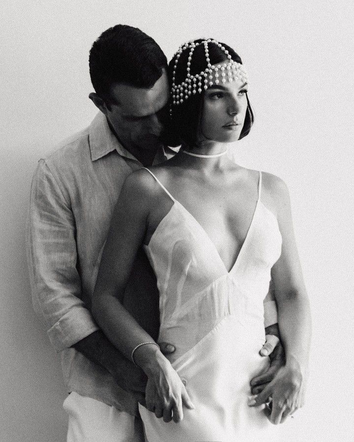 Foto de uma mulher morena usando um look composto por vestido e headpiece