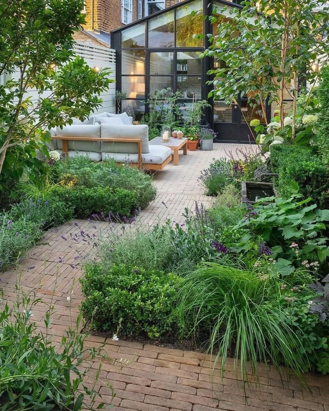 Jardim r&uacute;stico em quintal com caminho de pedras envolto por plantas