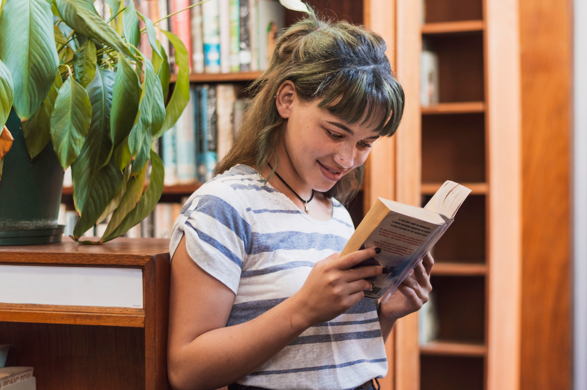 Imagem de menina jovem lendo livro em uma biblioteca