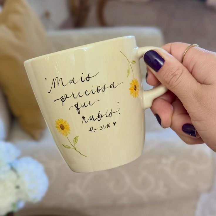 Caneca com frase afetiva “Mais preciosa que rubis” sendo segurada por uma pessoa.